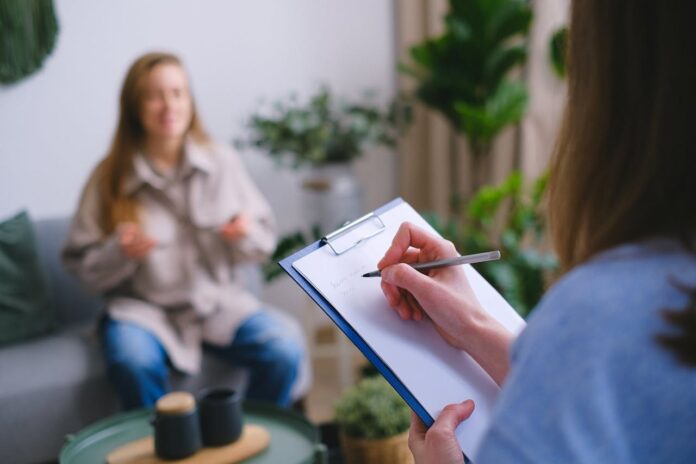 pexels-shvets-production-7176026.jpg Person taking notes during an interview with another individual in a cozy setting