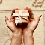 What Gratitude Really Does to the Brain Hands holding a small gift box with a ribbon